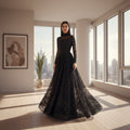Black sheer evening gown with long sleeves and a flowing skirt on a neutral background